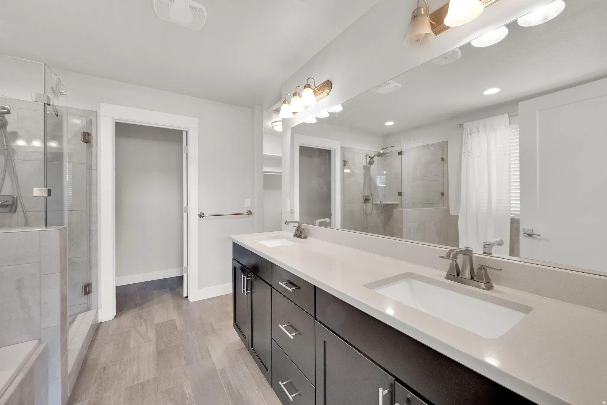 Dual vanity with integrated sinks, light-toned countertop, and dark wood-finish cabinetry
