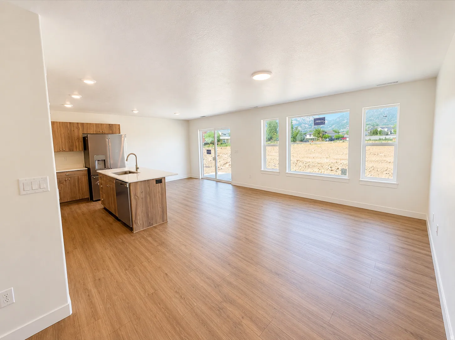 Open-concept living space featuring wood-finish flooring, recessed lighting, and expansive windows