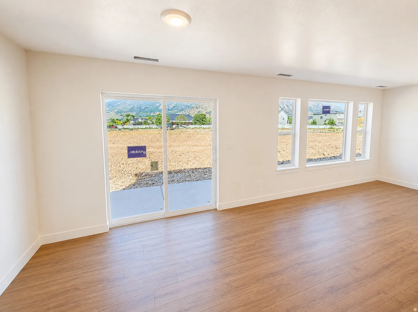 Room featuring light wood-finish flooring, white baseboards, and neutral wall paint