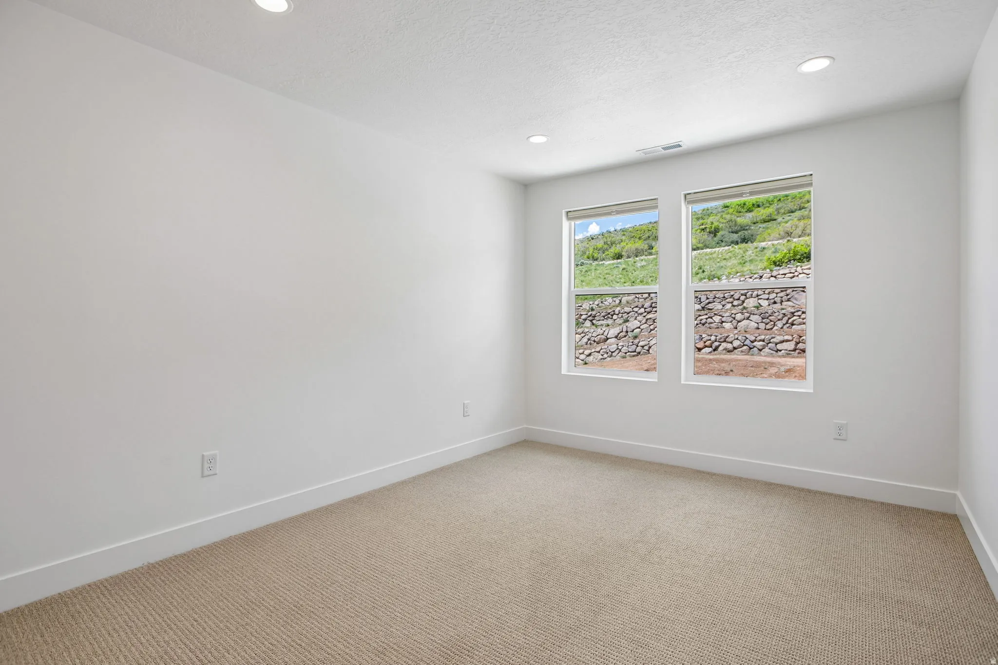 Room featuring white walls, recessed ceiling lights, and carpet flooring