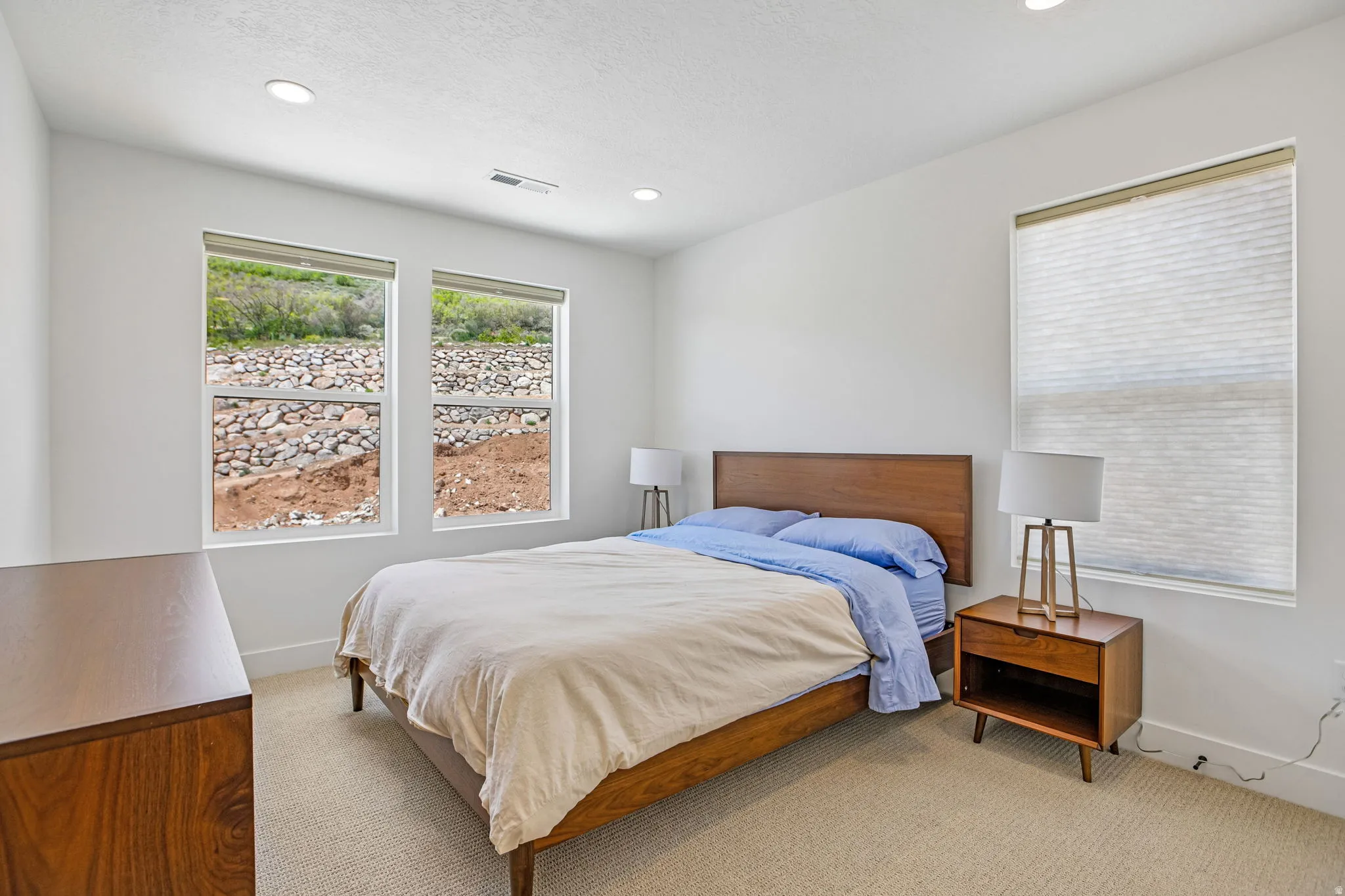 Neutral wall paint finishes complement the beige carpet flooring