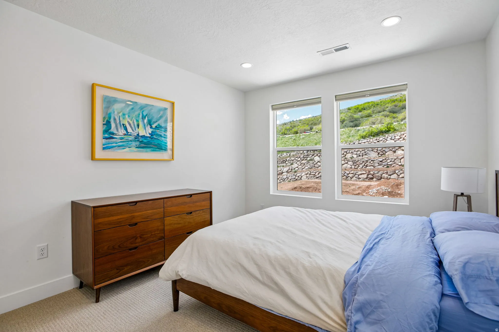 Bright room featuring two large windows, recessed lighting, and light-colored carpet