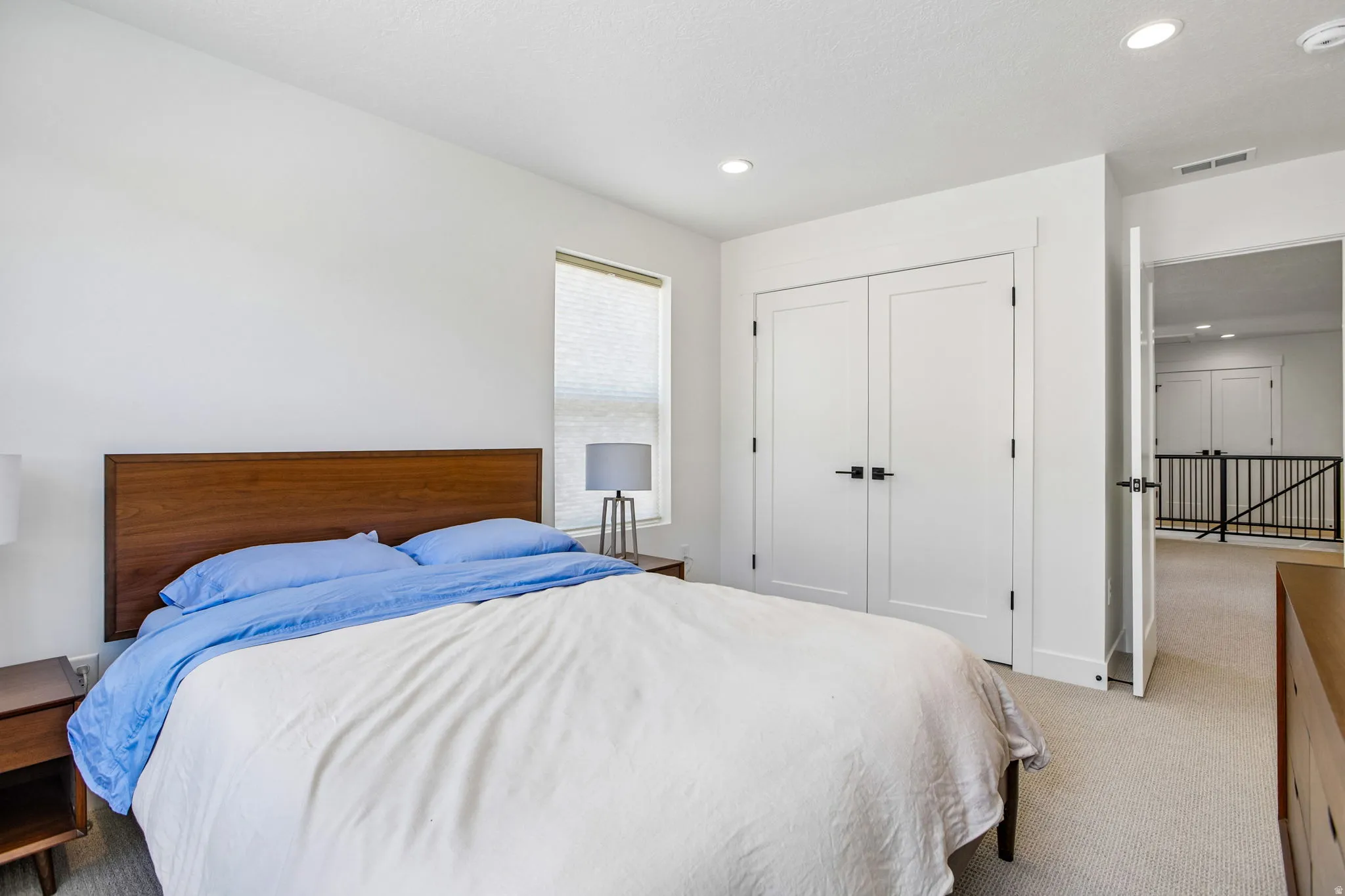 Bedroom featuring a single window with blinds, recessed lighting, and a double-door closet with dark hardware