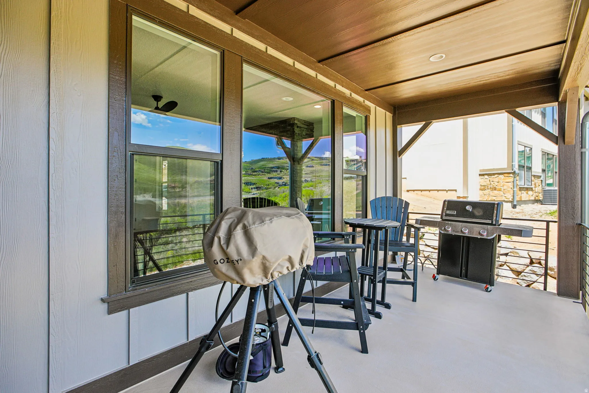 Covered outdoor patio featuring vertical siding, large windows, and a ceiling with recessed lighting