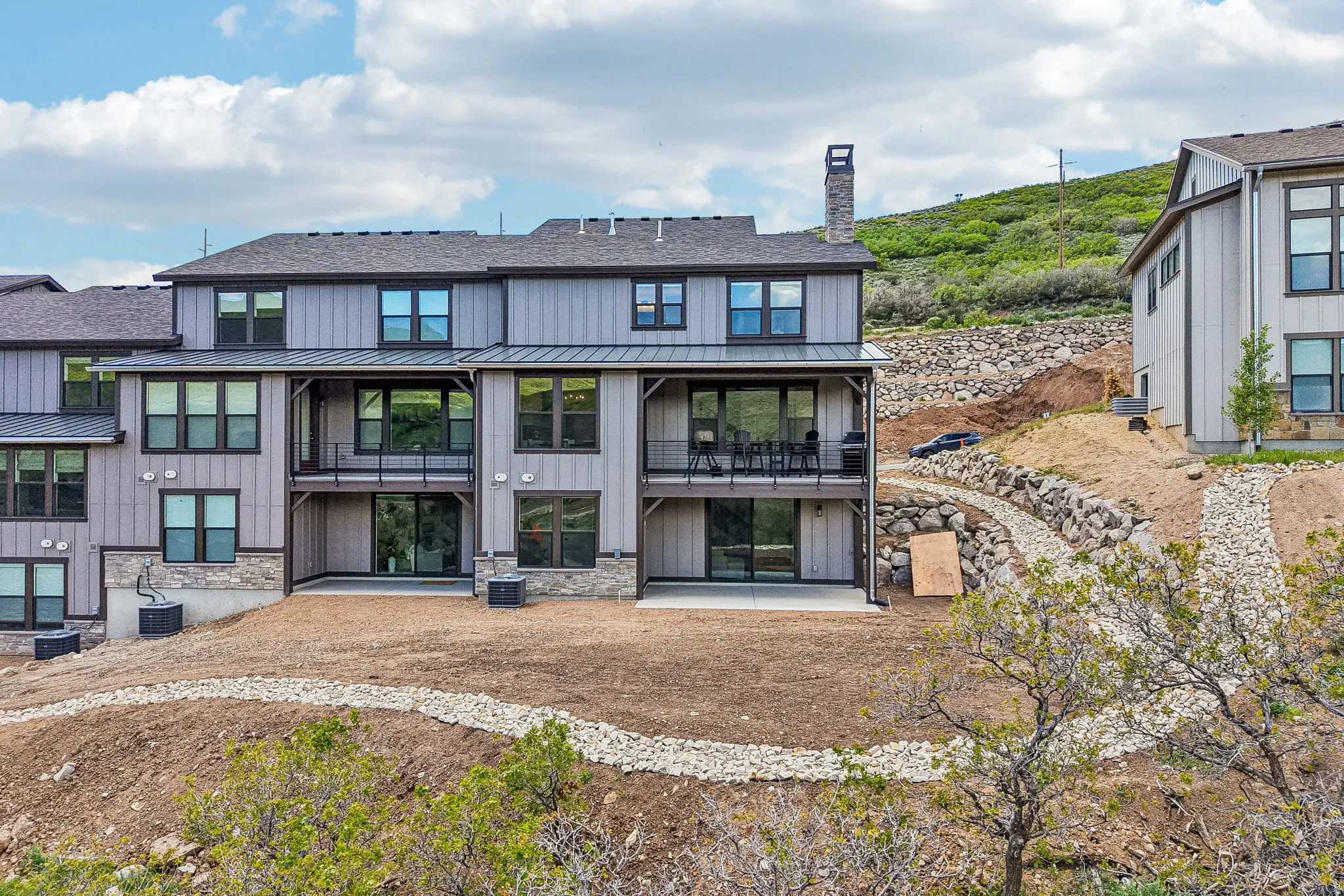 Multi-level property exterior with vertical siding and stone accents
