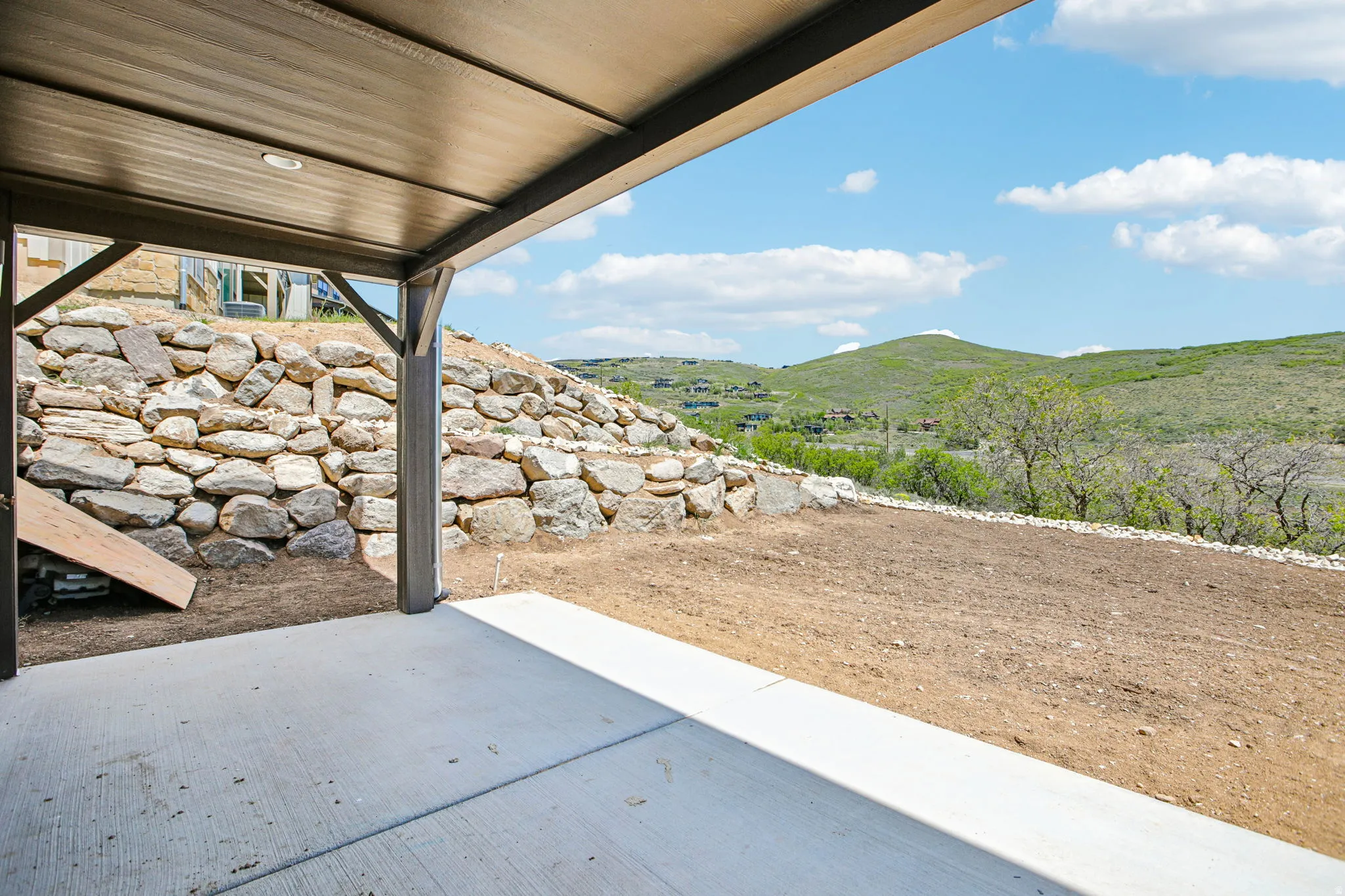 Covered concrete patio space featuring a durable overhead structure with recessed lighting