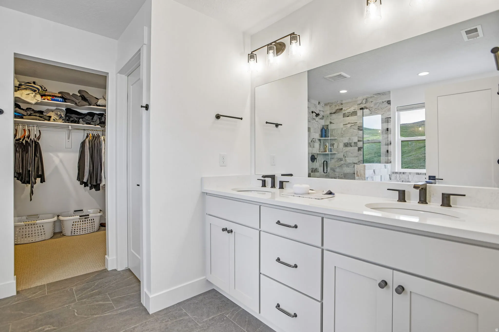 Double vanity with white cabinetry, integrated sinks, and dark bronze fixtures