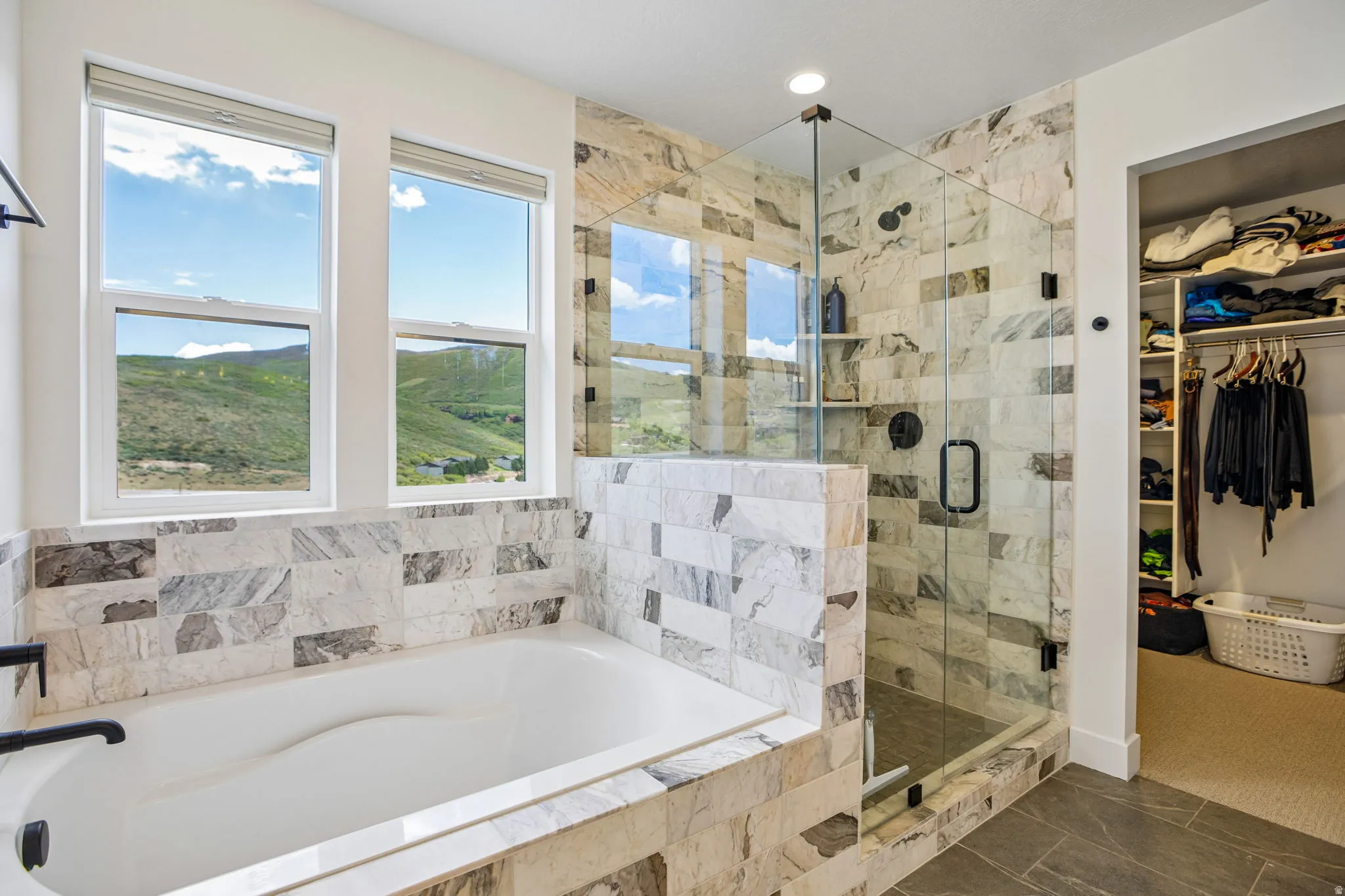 Soaking tub with matte black fixtures, set against a tiled surround