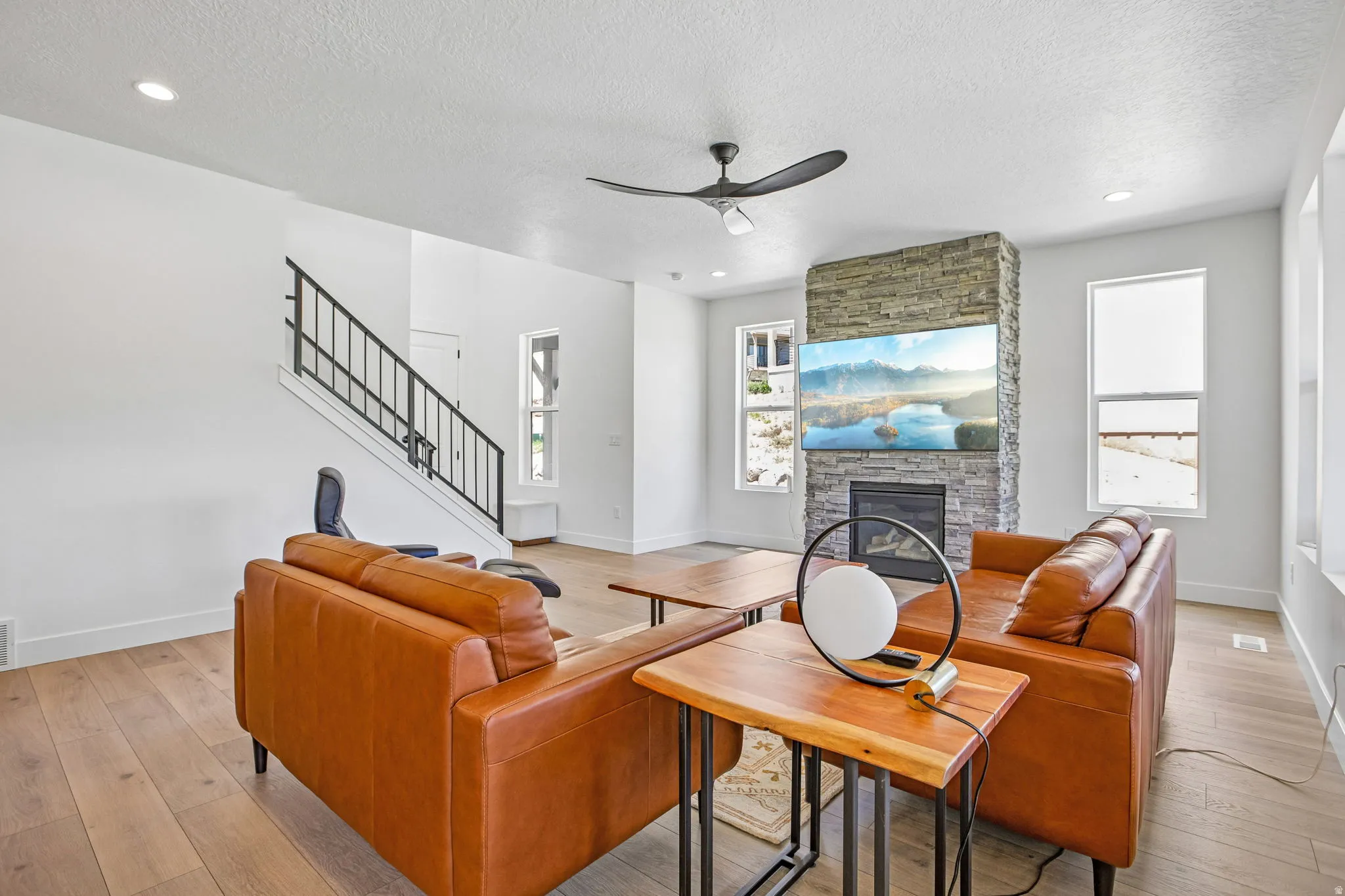 Living area featuring a floor-to-ceiling stone-clad fireplace with an integrated mantel