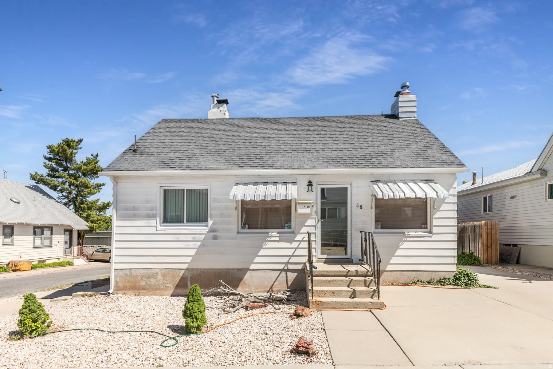 Single-story residence featuring white siding and a gray shingle roof