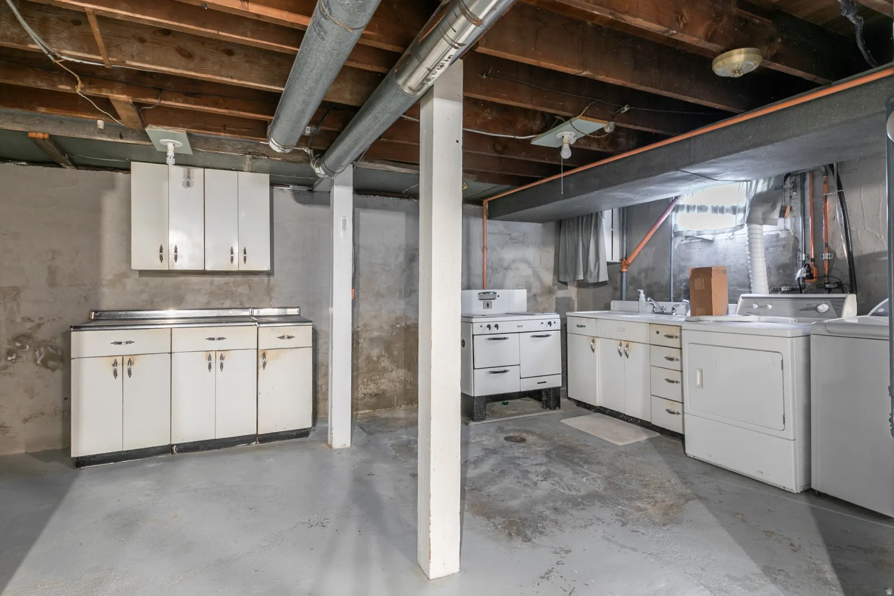 Unfinished basement with concrete flooring and exposed ceiling joists