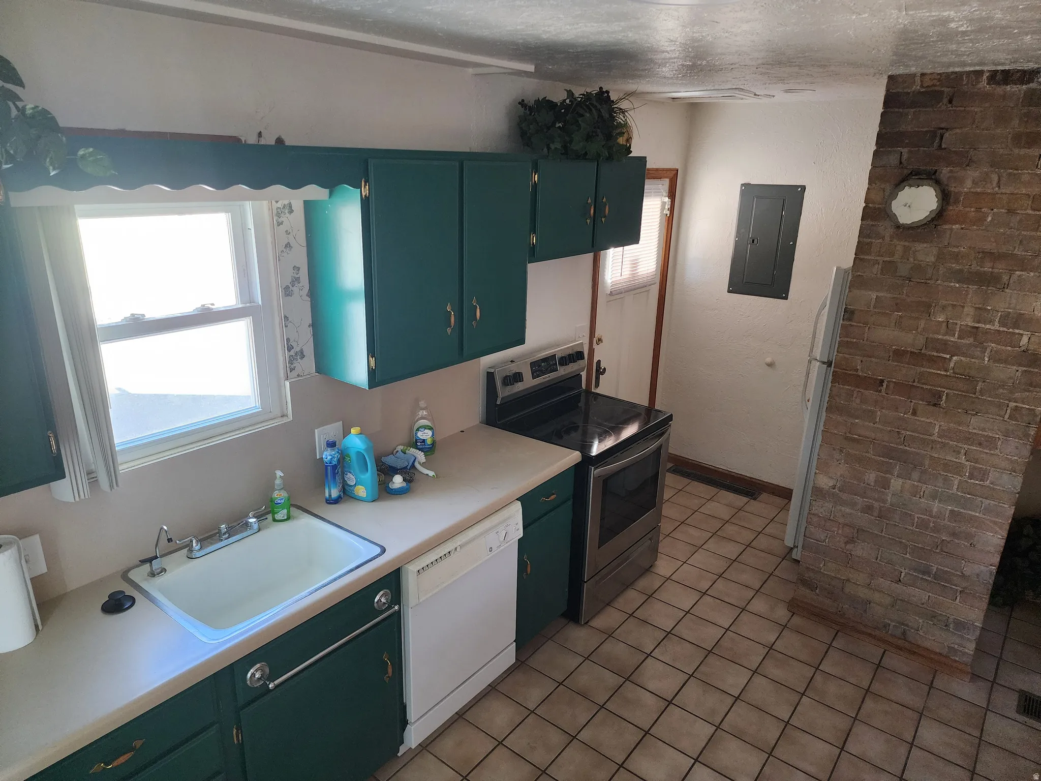 Kitchen featuring green cabinetry, a double basin sink, and a four-burner electric range