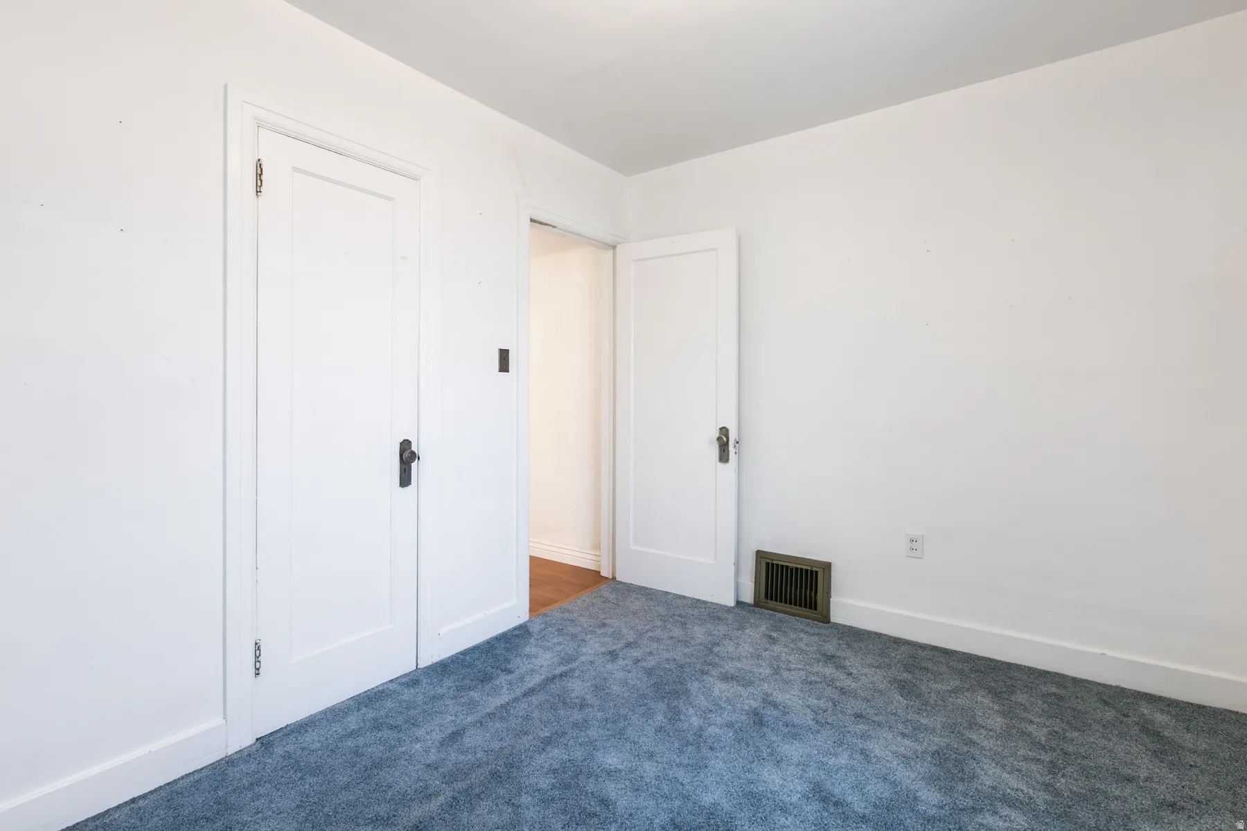 Interior room with light blue carpeting and white walls