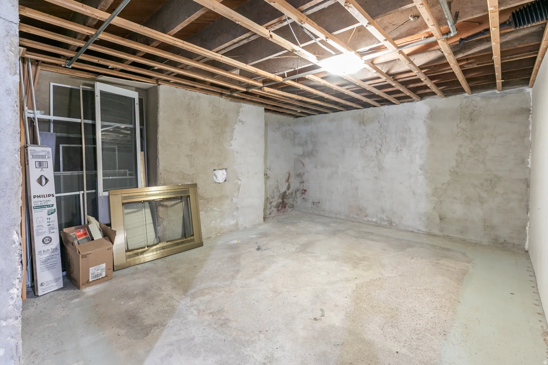 Unfinished basement space with exposed ceiling joists and a concrete floor
