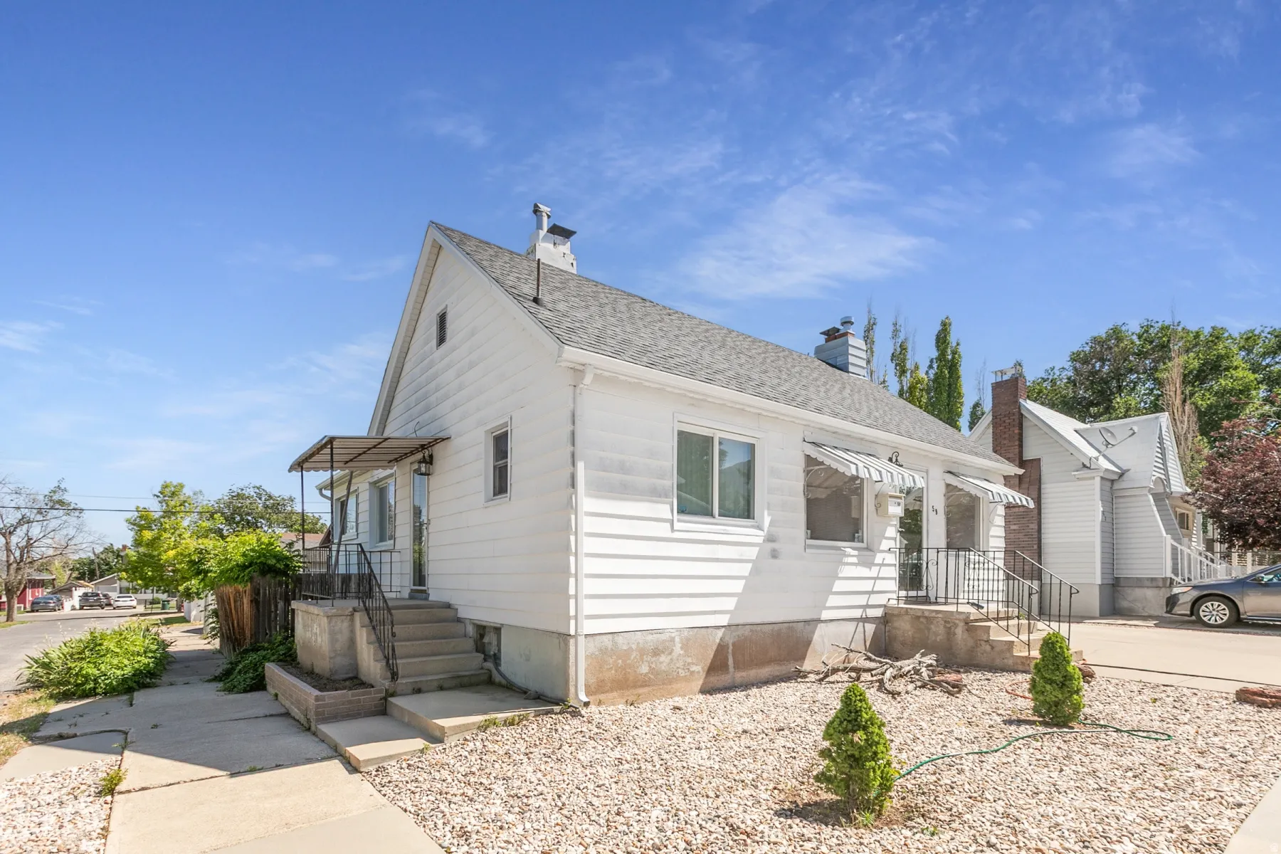White siding exterior with a pitched roof and a chimney