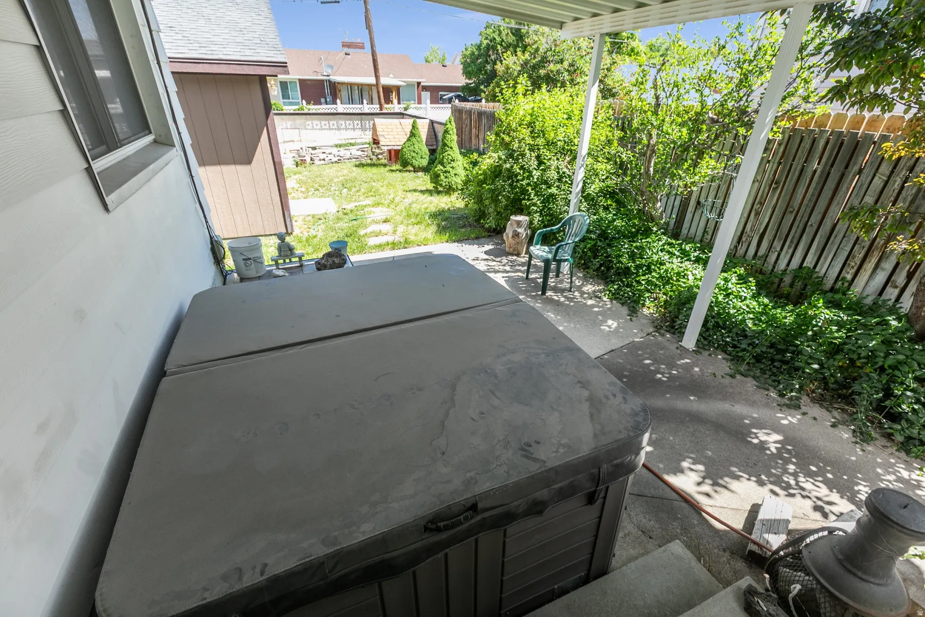 Exterior patio space featuring a hot tub, concrete paving, and a covered pergola