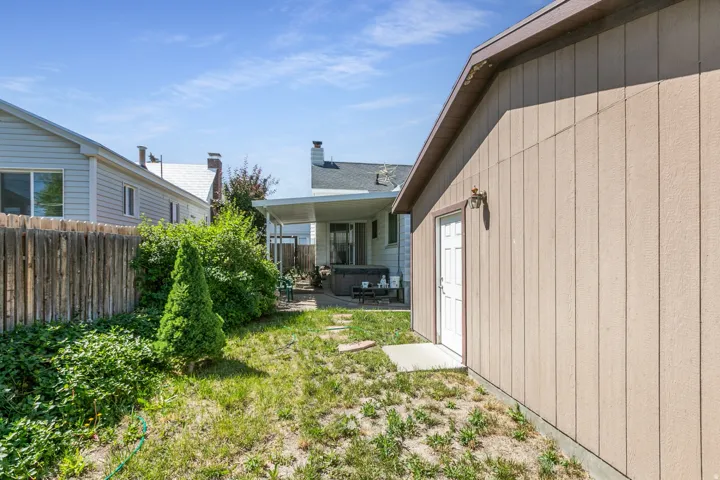 Freestanding accessory structure with board-and-batten style siding and exterior lighting