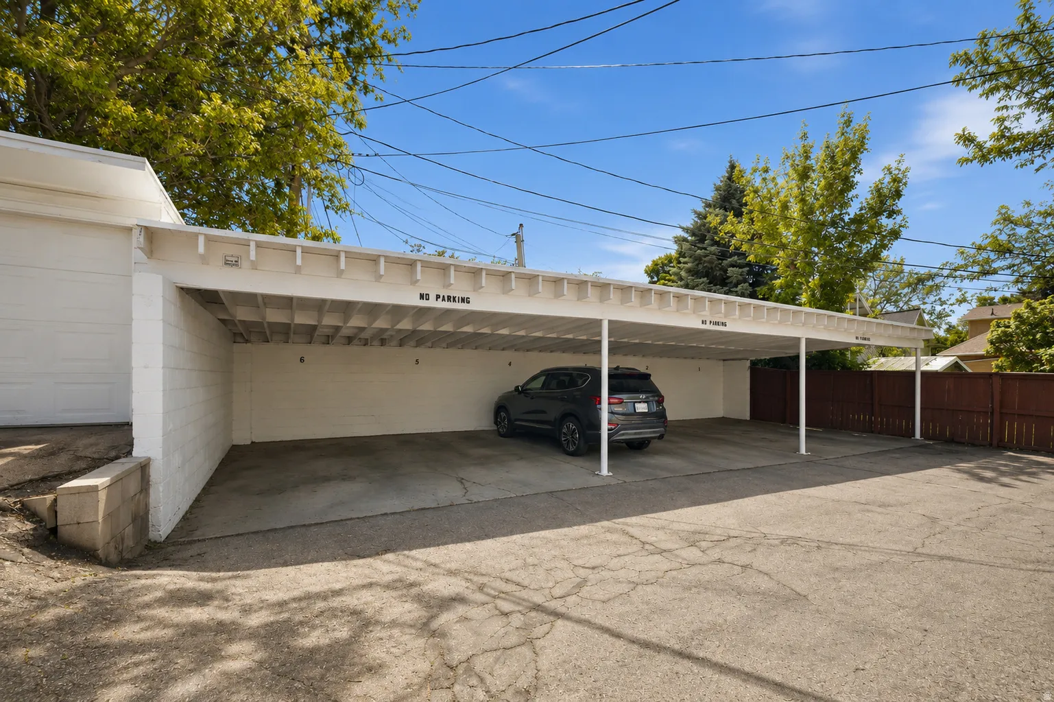 Covered parking structure with open-air sides and a solid roof