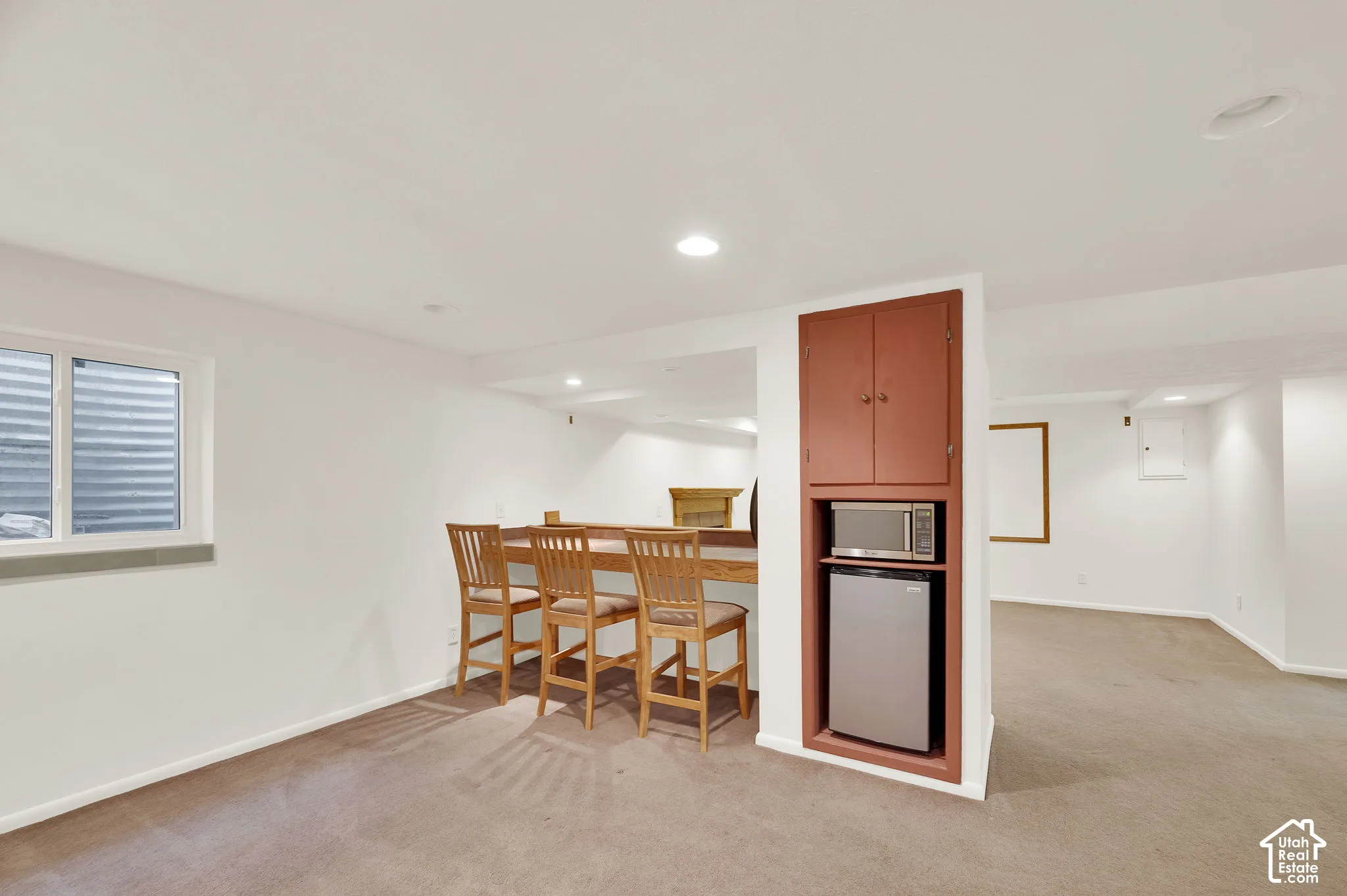 Lower-level space featuring a built-in bar with wood-finish countertop, recessed lighting, and carpeting