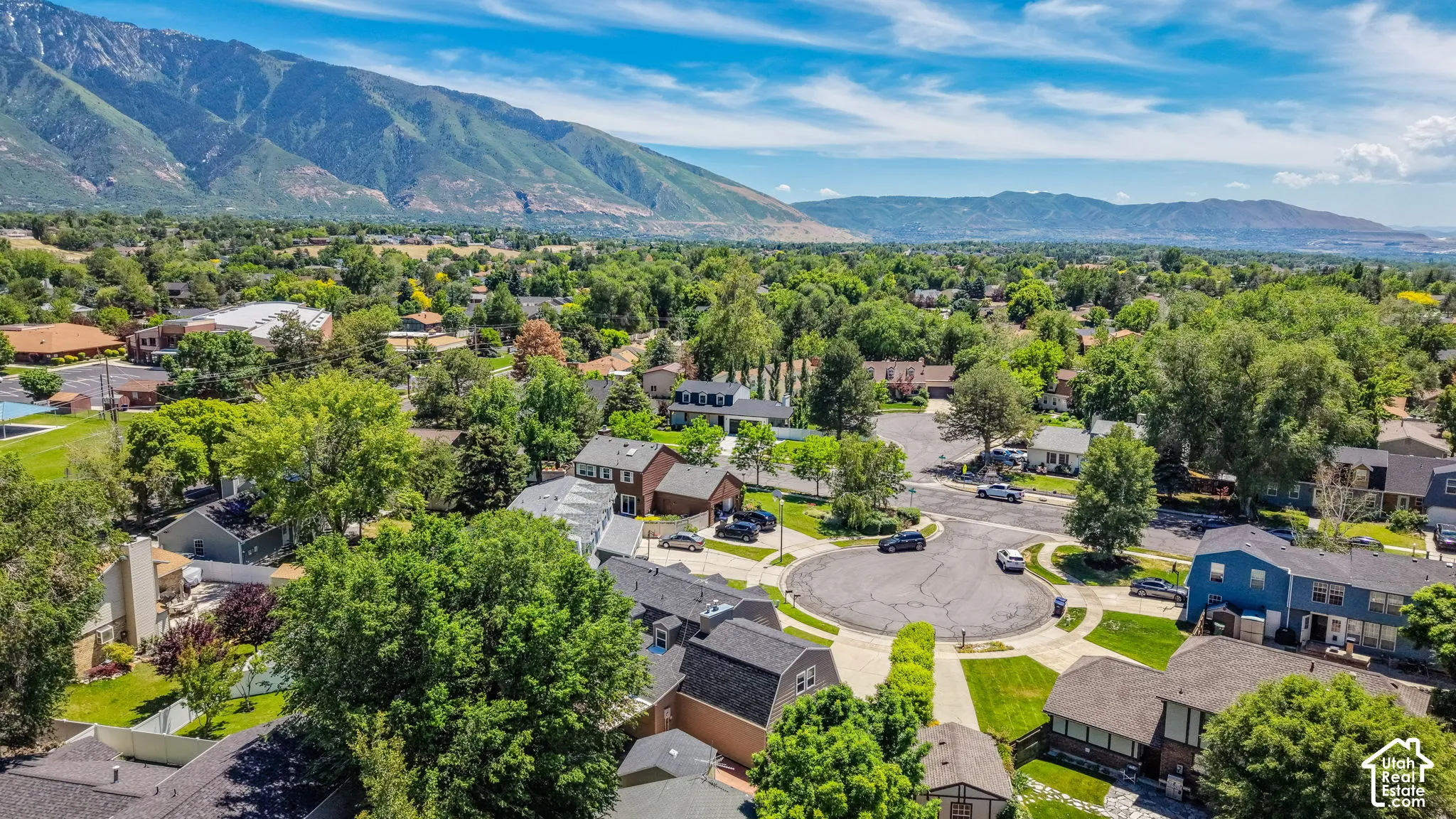 Residential neighborhood featuring a cul-de-sac, mature trees, and mountain scenery