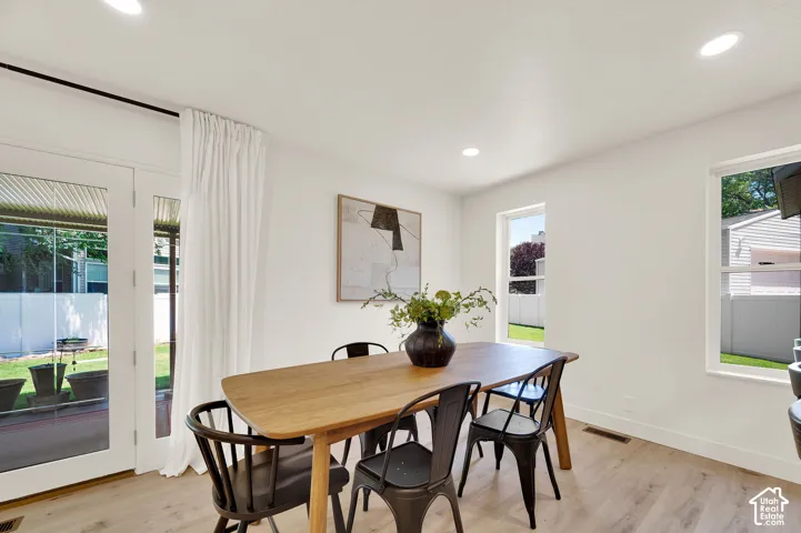 Dining area featuring light wood-finish flooring, recessed lighting, and white walls