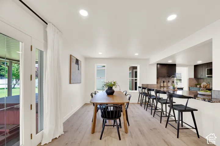Open-concept dining area featuring light wood-finish flooring and recessed lighting