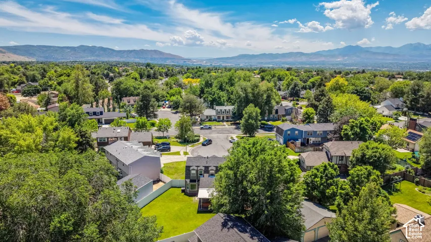 Expansive residential neighborhood featuring numerous mature trees and mountain scenery in the distance