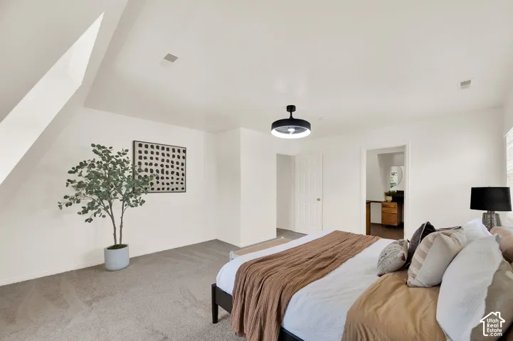Carpeted room featuring a sloped ceiling detail, recessed lighting, and a modern ceiling light fixture
