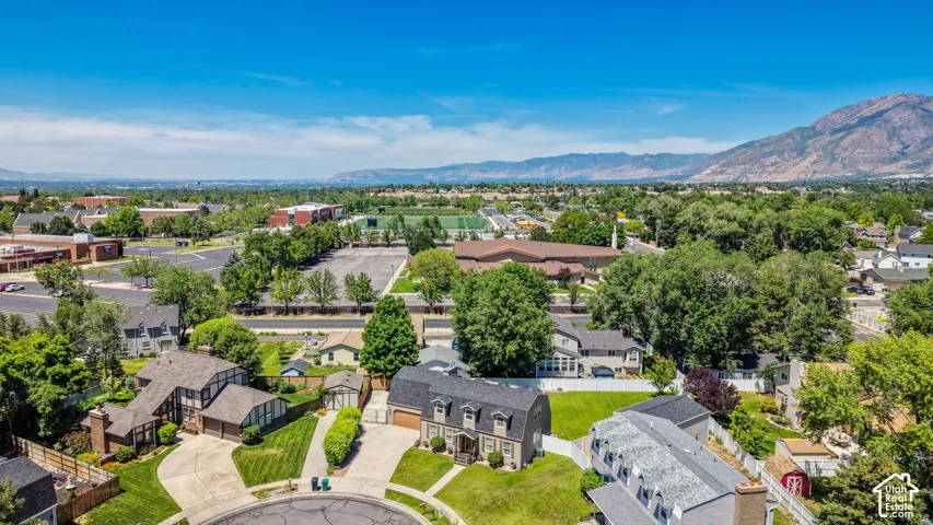 Aerial perspective showcasing a residential neighborhood with surrounding infrastructure and distant mountains