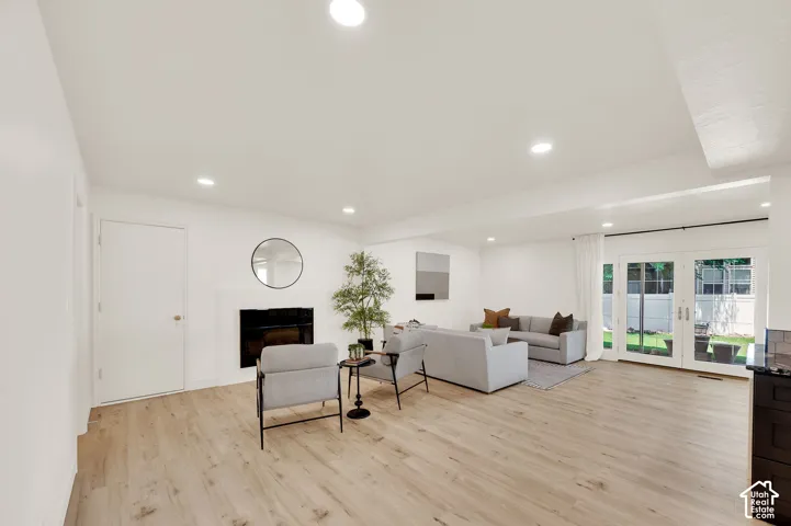 Spacious living area featuring wood-finish flooring, recessed lighting, and a white mantel fireplace