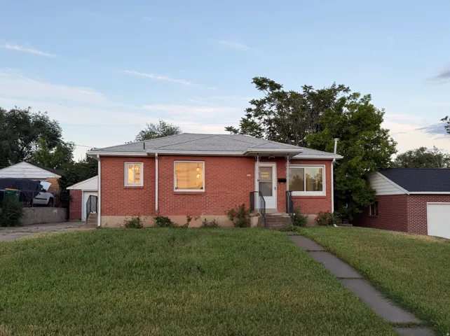 Brick exterior with a gray shingle roof and white trim