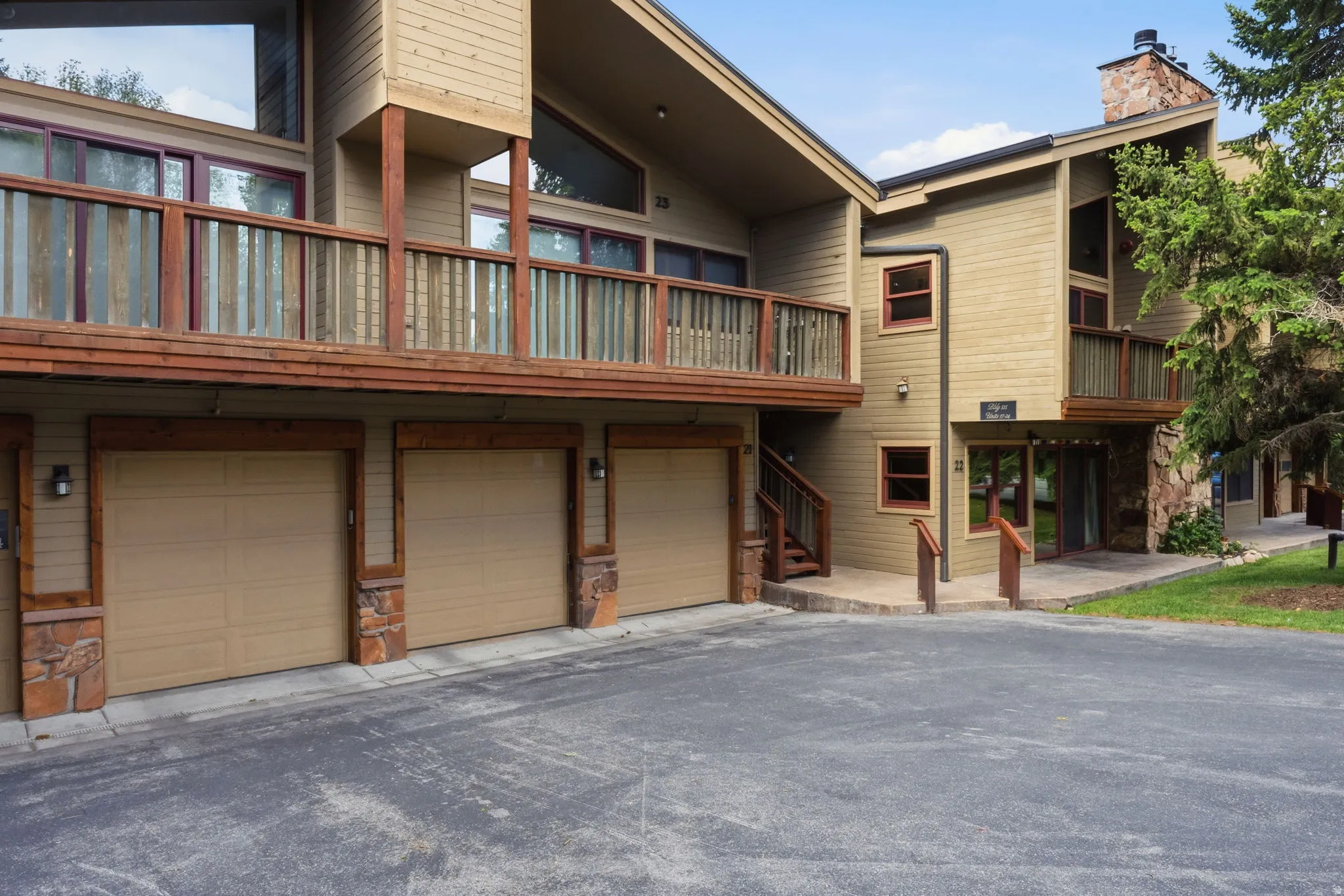 Second garage from the right unit 22.  Multi-level exterior featuring wood siding, stone accents, and multiple balconies