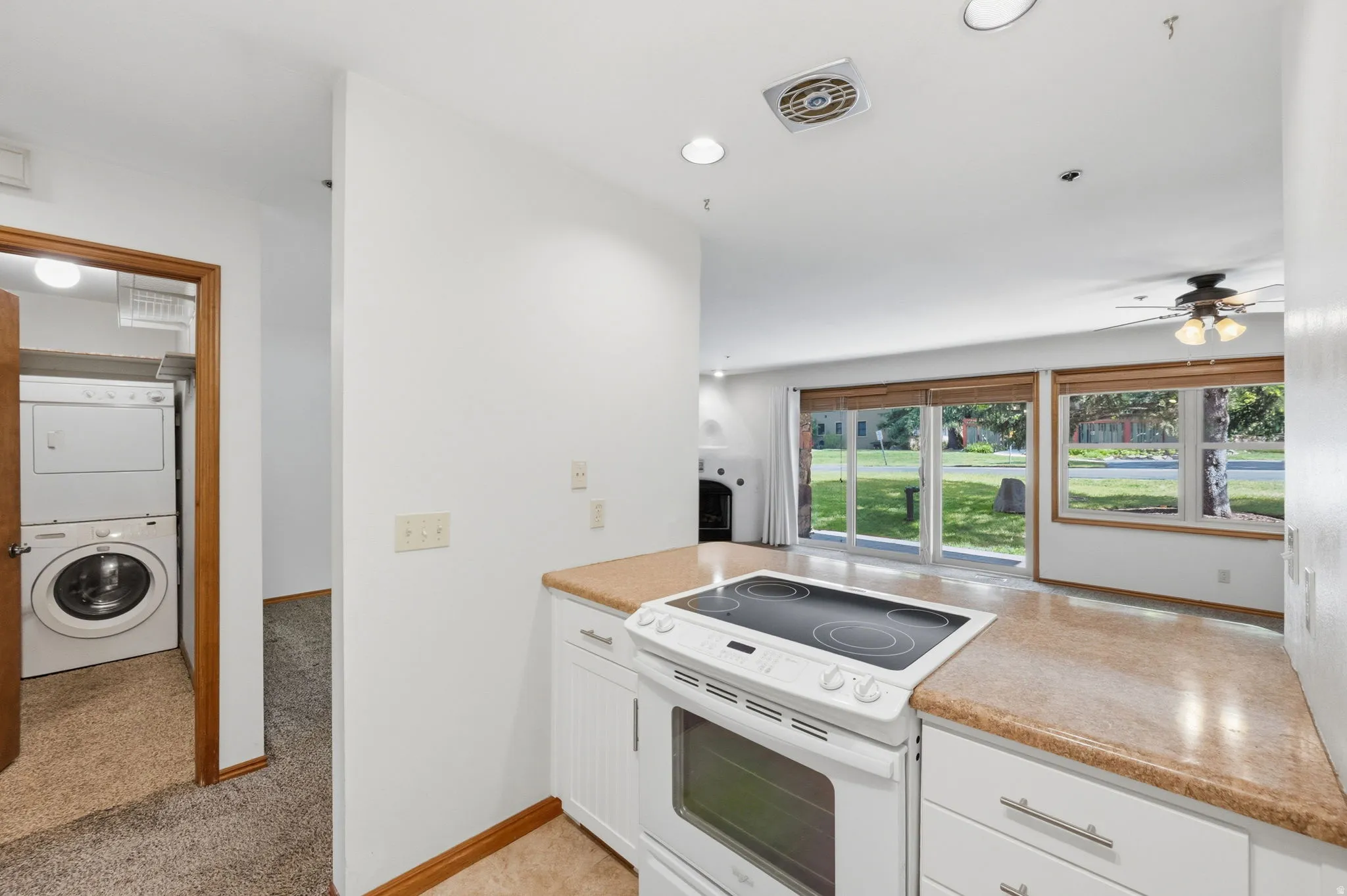Kitchen featuring white cabinetry, light-colored countertops, and a white electric range