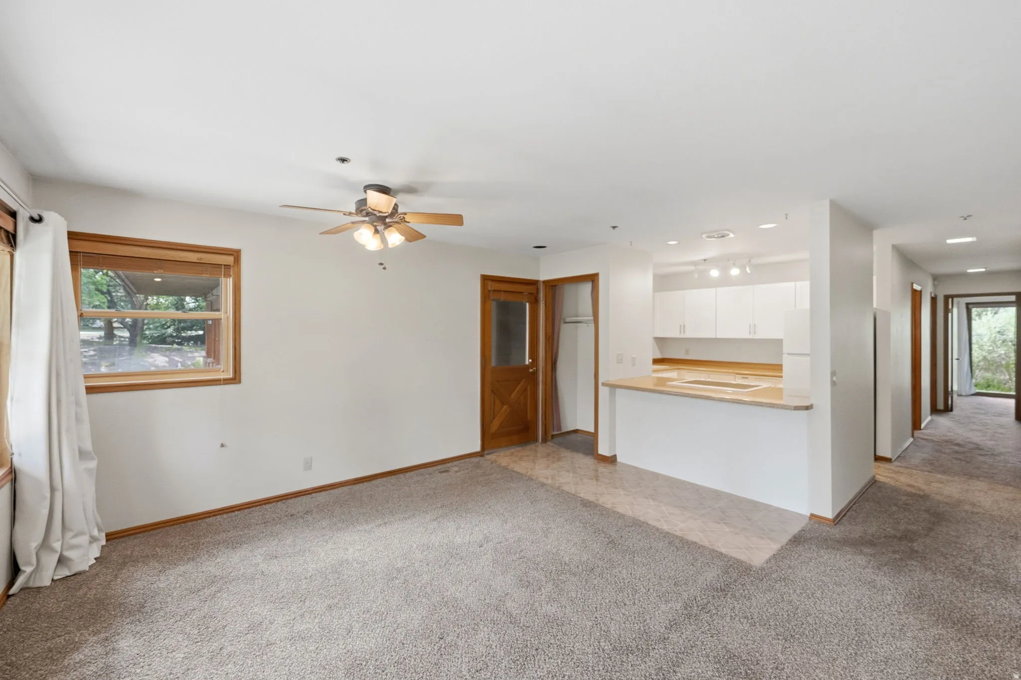 Open-concept living area featuring a breakfast bar, white cabinetry, and recessed lighting