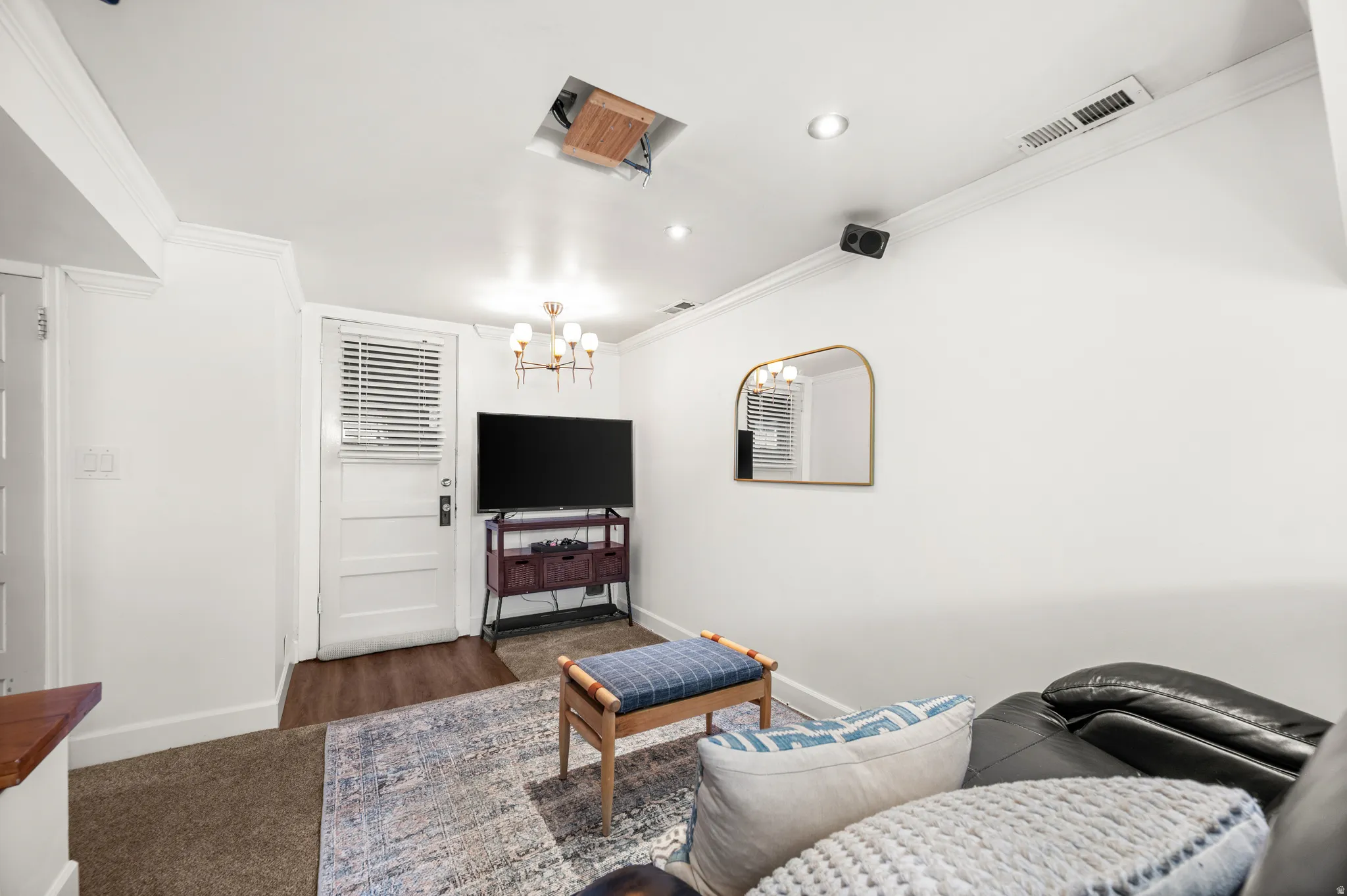 Versatile interior space featuring recessed lighting, a modern chandelier, and crown molding