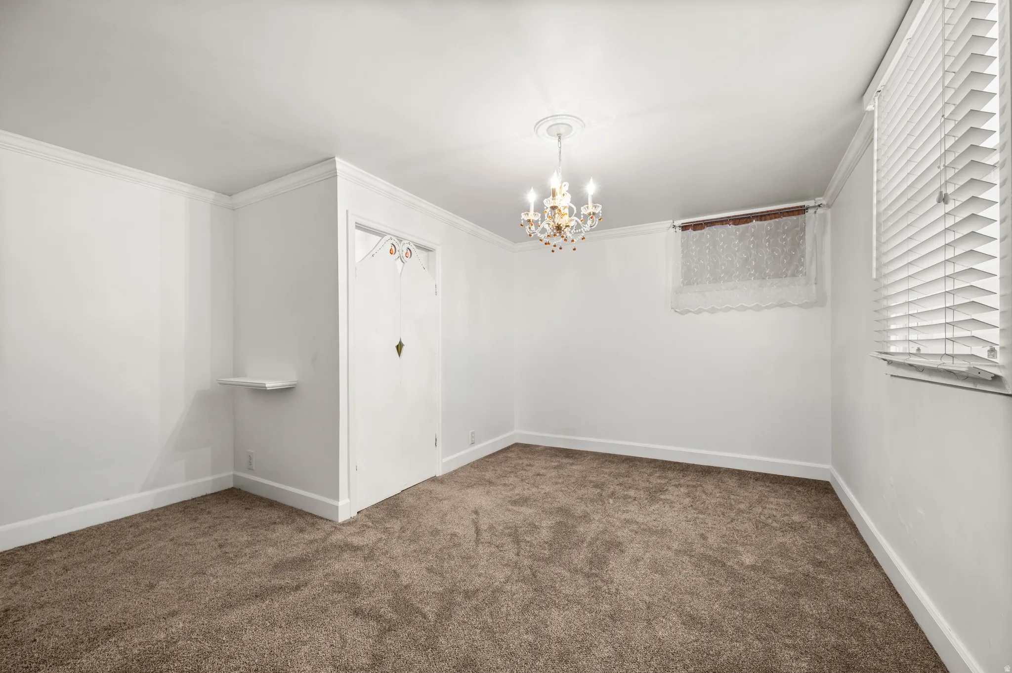 Spacious room featuring neutral carpeting and white walls