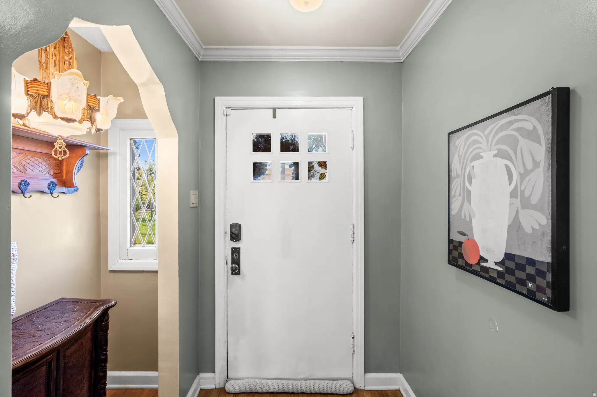 Entryway featuring a white paneled door with square glass inserts and dark hardware