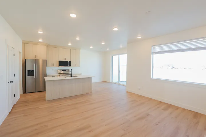 Open-concept living space featuring wood-finish flooring, recessed lighting, and a kitchen with light-toned cabinetry