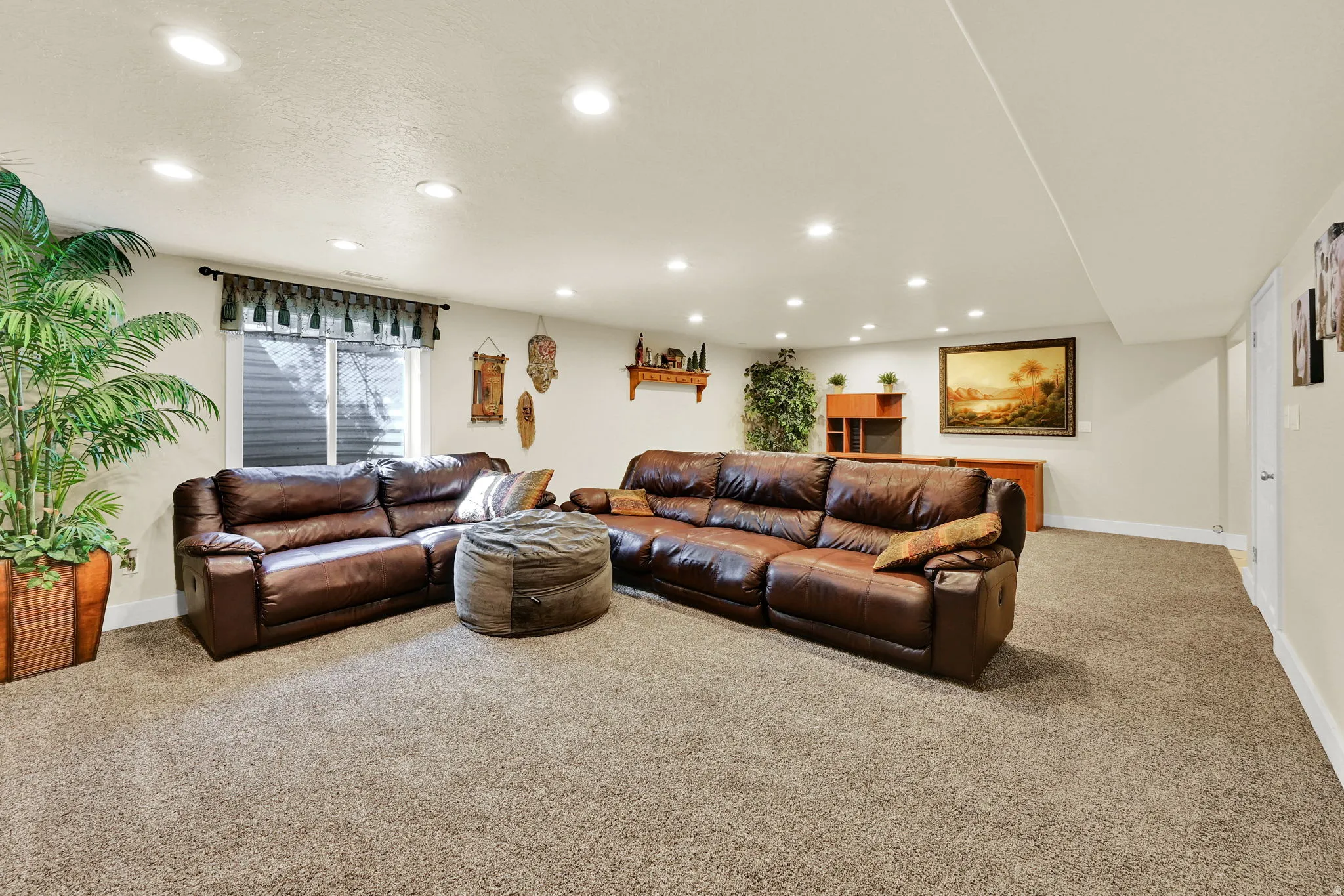 Spacious recreation room featuring recessed lighting, light-toned carpeting, neutral wall paint, and a window with blinds