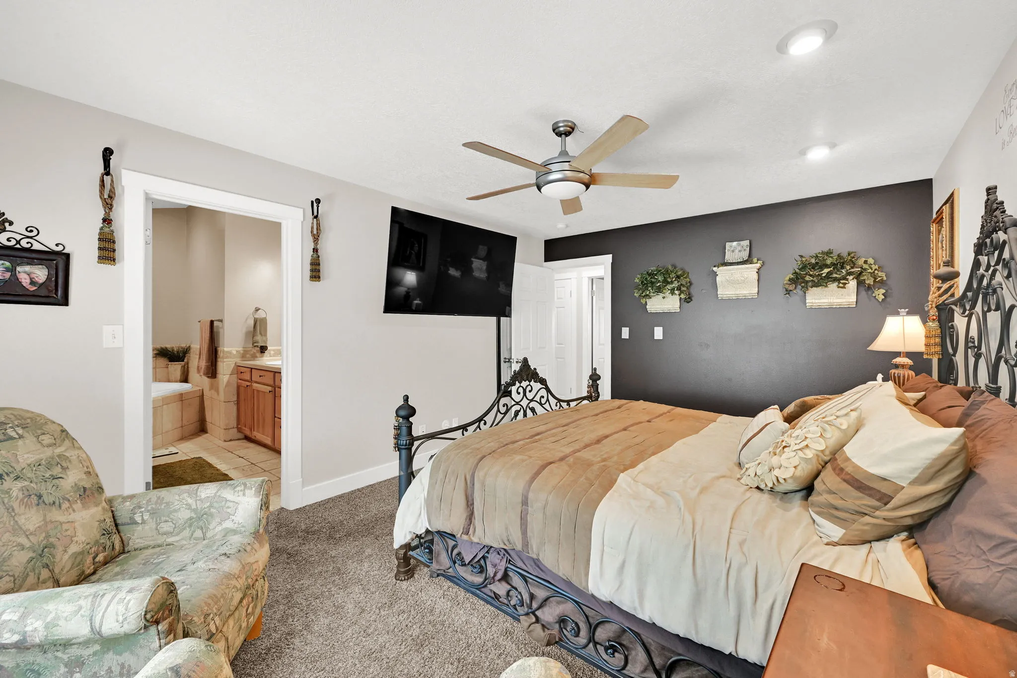 Carpeted bedroom featuring a ceiling fan, recessed lighting, and a dark accent wall