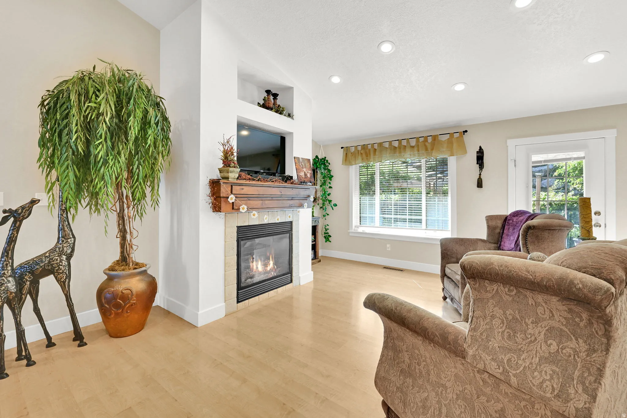 Living area featuring a gas fireplace with a tiled surround and wood mantel
