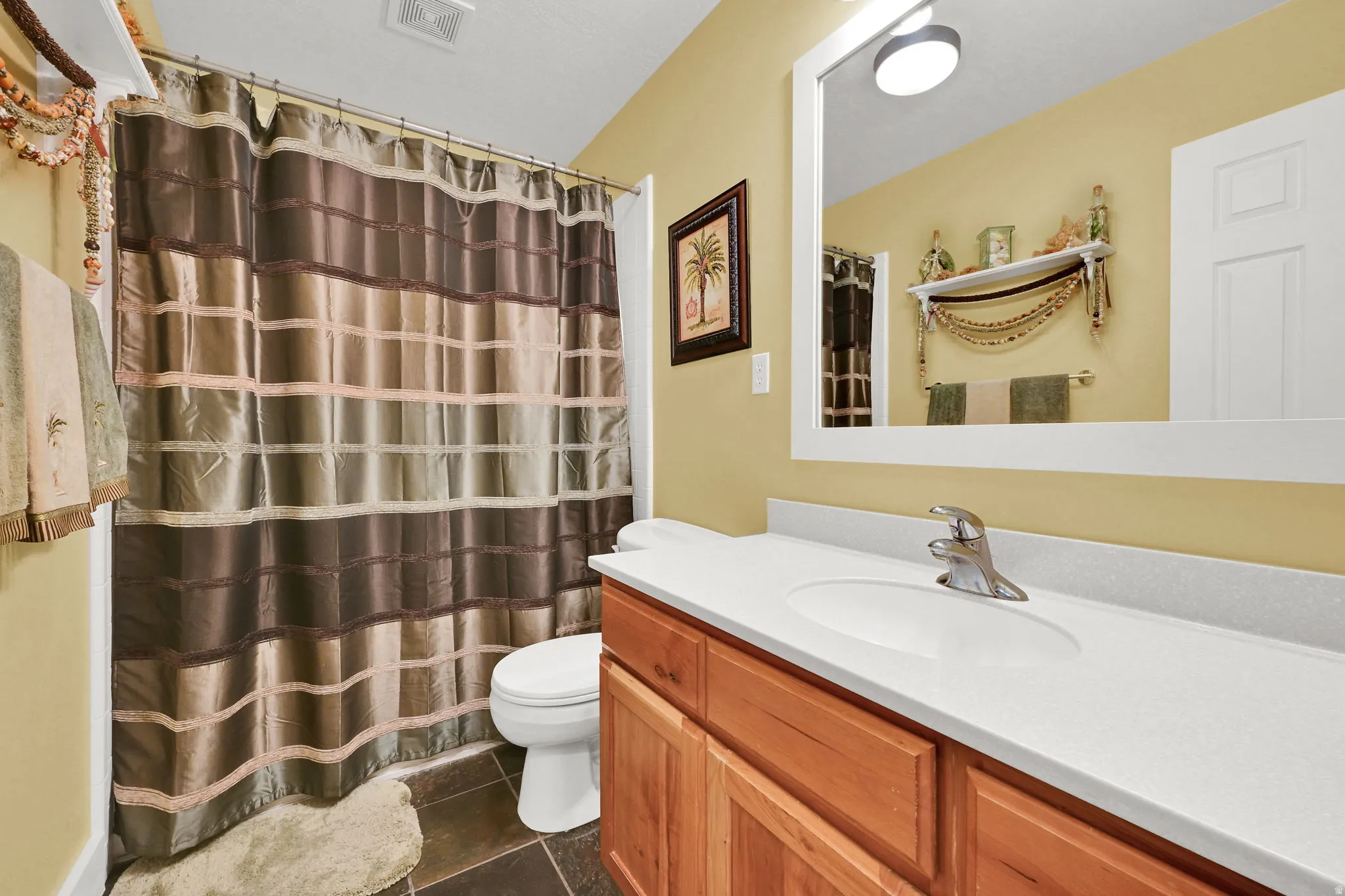 Bathroom featuring a single vanity with wood cabinetry, a white countertop, and an integrated sink