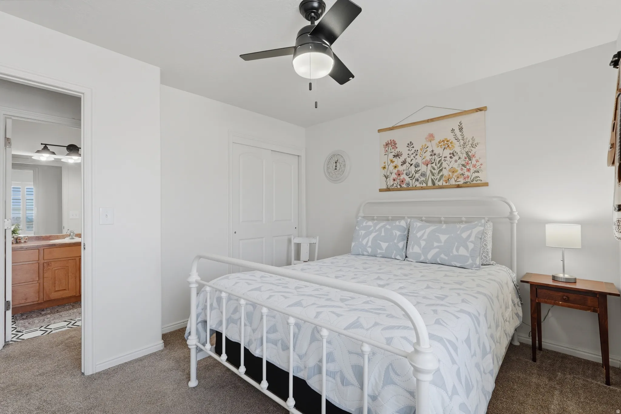 Bedroom featuring a ceiling fan with integrated lighting, carpet flooring, and a double-door closet