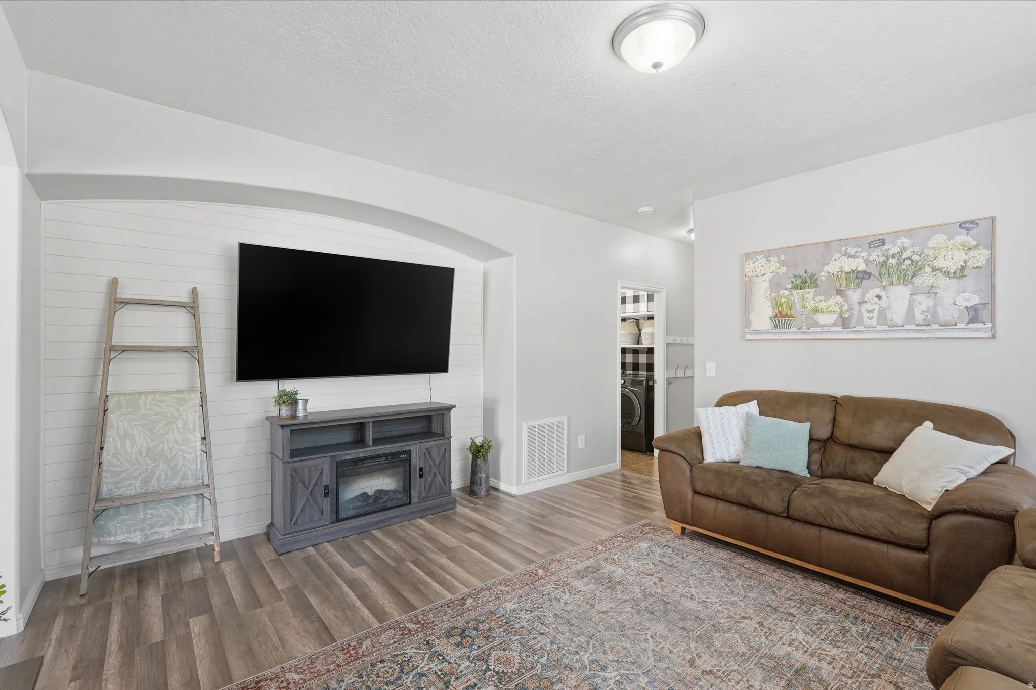Living area featuring an arched alcove with shiplap accent wall, wood-finish flooring, and recessed lighting