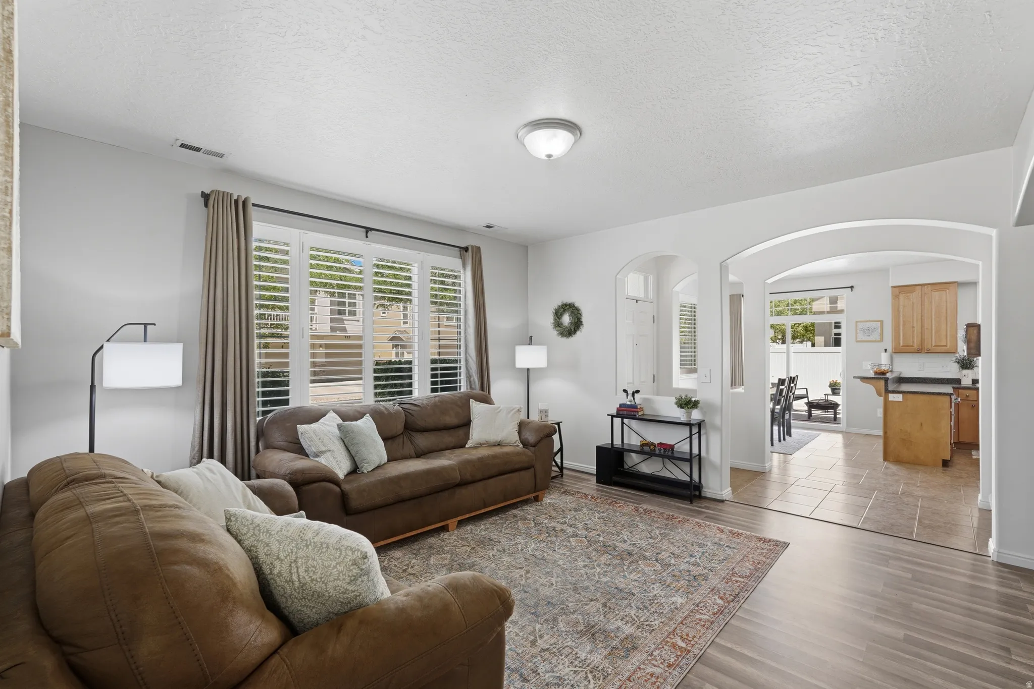 Living area featuring wood-finish flooring, white walls, and recessed lighting