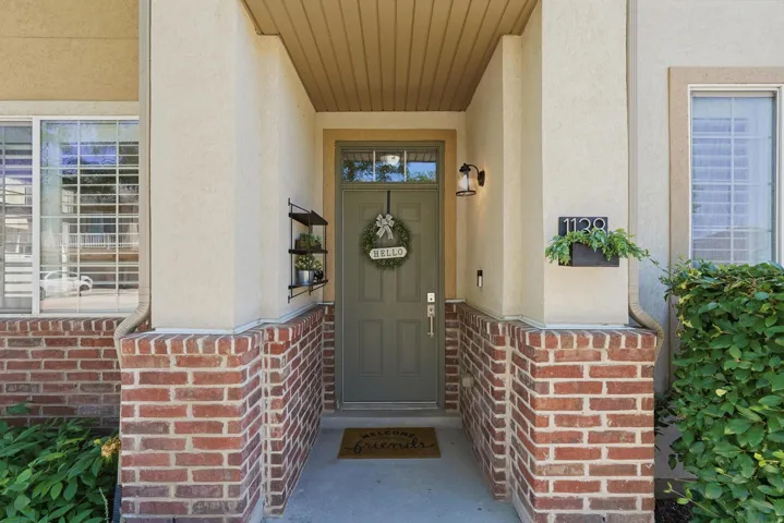 Entryway featuring a paneled door, exterior sconce lighting, and a brick facade