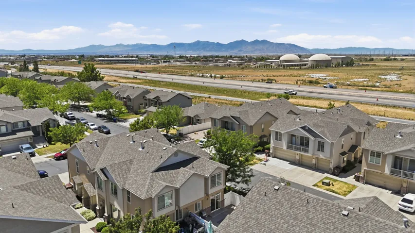 Aerial perspective of residential community featuring multi-story homes with shingle roofs and integrated garages