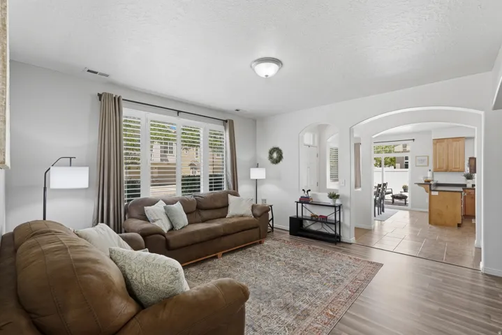Living area featuring wood-finish flooring, white walls, and recessed lighting