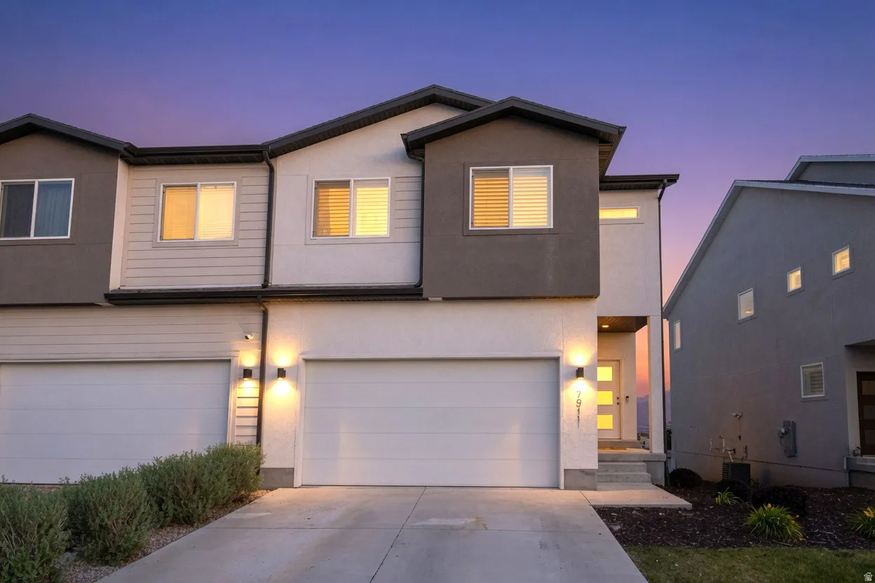 Contemporary multi-level residence featuring a gray and white exterior with dark trim