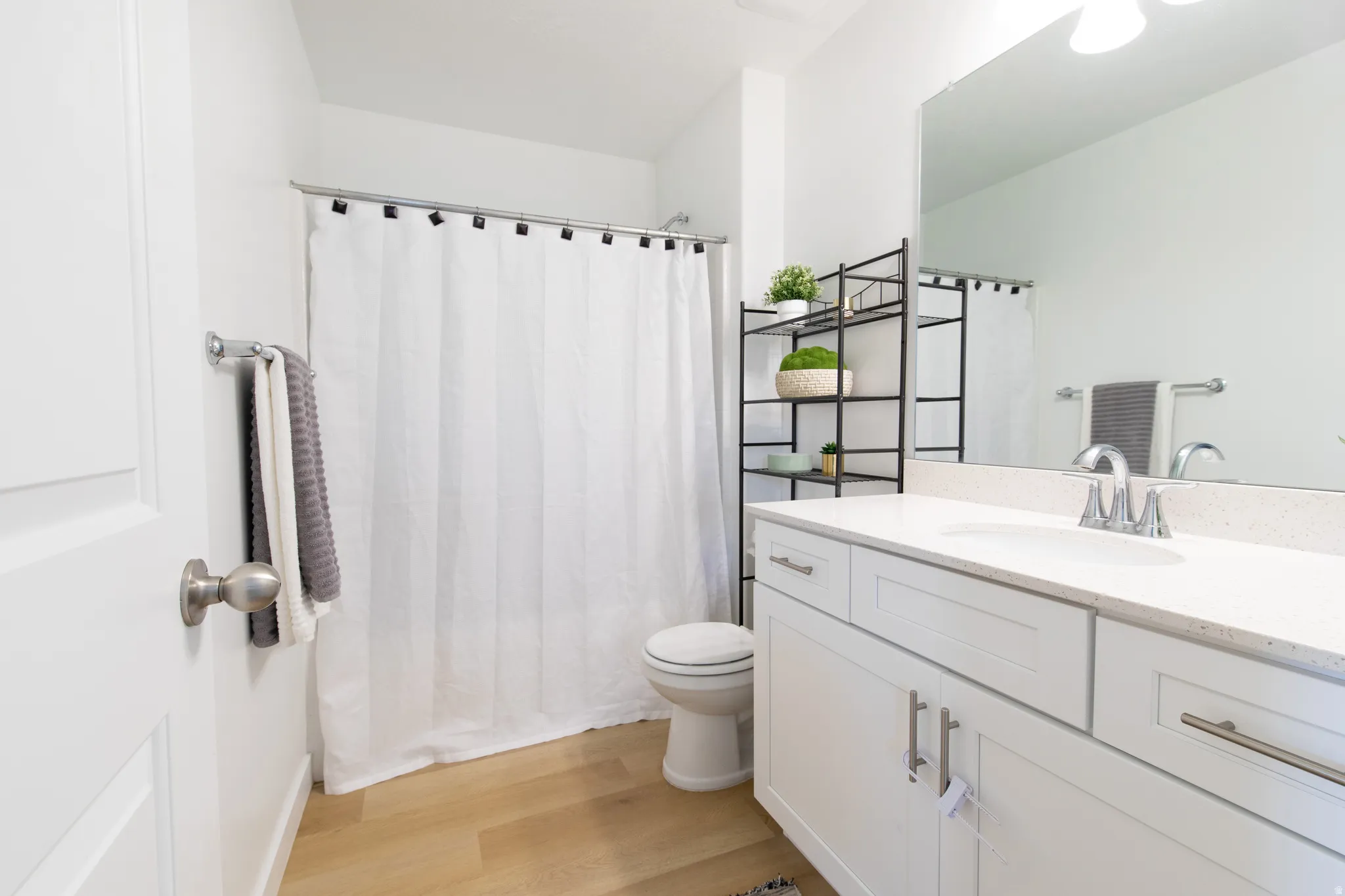 Bathroom featuring a white vanity with silver hardware, an integrated white sink, and a light-toned countertop